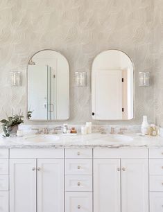 a bathroom with two sinks and mirrors on the wall