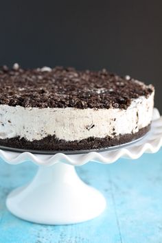 an oreo cookie cake with white frosting on a blue tableclothed surface