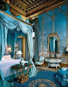 an ornate bedroom with blue walls and curtains