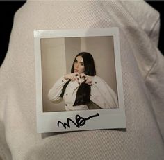 a polaroid photograph of a woman wearing a white jacket and black tie with her hands on her hips