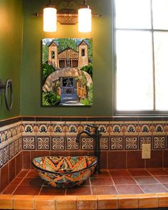 a bowl sink sitting on top of a tiled counter next to a window in a bathroom