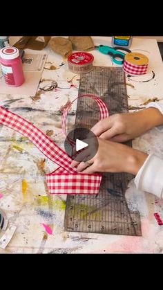 a woman is working on some crafting items with scissors and paper machs in front of her