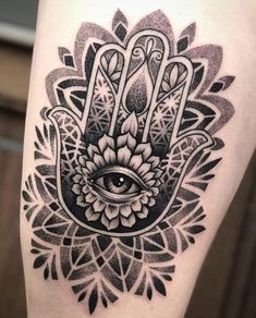 a black and white hamsa tattoo on the leg