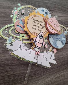 a close up of a cake topper on a wooden table with clouds and donuts