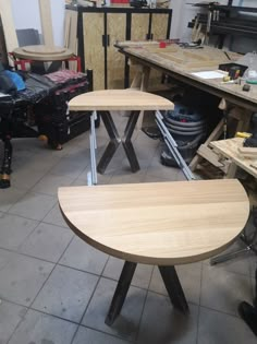 three wooden stools sitting on top of a tile floor in a room filled with tools