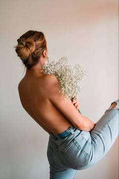 a woman holding a bouquet of baby's breath in her right hand and back to the camera