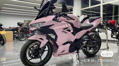 a pink motorcycle is parked in a showroom