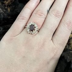 NV Garnet Halo Sterling Silver RingPreowned ring stamped with 925 and NV 7 logo inside of the band. Prong set oval red garnet in the center and then there are 8 small clear round cz stones on the sides. The shape looks like a flower. There are some scratches on the surface of the sterling but overall in good condition.Please note the Presidium Gem Tester II does not distinguish between lab grown gems and ones found in the earth which are chemically the same. Please see pictures for details. US Size 73.2 gramsOval gemstone is 8.0 mm x 6.0 mm x 2.3 mmApproximate carat weight is .86 cts Please note that color may vary a small amount because of my lighting. If you have questions please ask and I would be happy to help! -Michelle Classic Oval Garnet Cluster Ring, Oval Garnet Jewelry With Halo Setting, Red Oval Garnet Cluster Ring, Oval Red Garnet Cluster Ring, Oval Cabochon Garnet Jewelry For Anniversary, Anniversary Garnet Oval Cabochon Jewelry, Oval Garnet Ring With Halo Setting, Red Oval Cluster Ring With Birthstone, Oval Garnet Ring In Silver