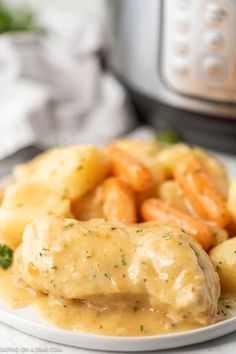 a white plate topped with chicken and gravy next to an instant pot