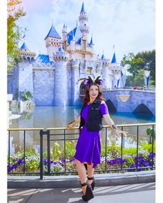 a woman is posing in front of a castle