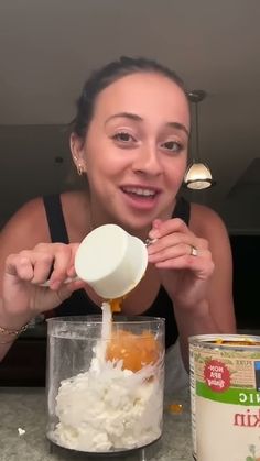 a woman is mixing ingredients in a blender for her breakfast recipe with yogurt and granola