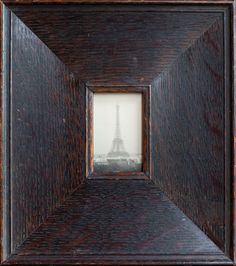 the eiffel tower is seen through an old wooden frame with a small window in it