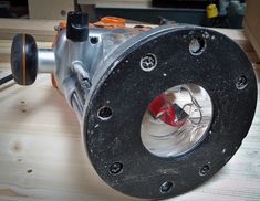 a close up of a metal object on a wooden table with wires and other items