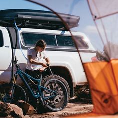 a man is working on his bike in the dirt