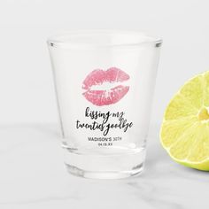 a shot glass with lipstick on it next to a lemon slice and the words add your text here