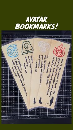 four bookmarks with writing on them sitting on top of a piece of paper next to a grid