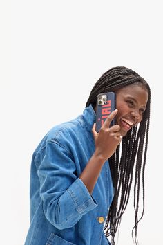 a woman with dreadlocks holding up a cell phone