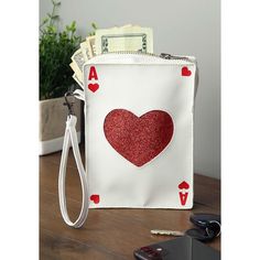 Looking to have an ace up your sleeve? This Ace of Hearts Purse is exactly what you need! The purse is designed to look like a classic playing card and comes with enough space inside for your necessities for the evening. The wrist strap makes it easy to carry, so you'll be ready with an ace at any event! Queen Of Hearts Wig, Ace Of Hearts Card, Ace Ventura Costume, Kiss Costume, Queen Of Hearts Makeup, Queen Of Hearts Card, Card Costume, Addams Family Costumes, My Little Pony Costume