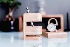 a desk with a clock, pen holder and alarm clock on it's stand