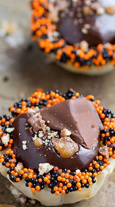 chocolate covered donuts with sprinkles and nuts on the top are ready to be eaten