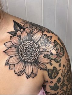 a woman's shoulder with flowers and butterflies on it