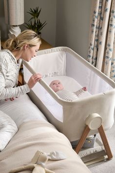 a woman standing next to a baby in a crib