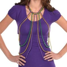 a woman wearing a purple top and beaded necklace with green beads on her neck