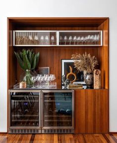 a wooden cabinet with wine glasses and bottles