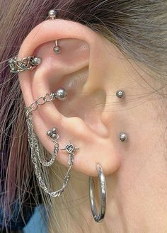 a close up of a person with some piercings on their ear and behind the ear