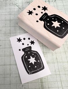 a rubber stamp with a jar and stars on it next to a piece of paper