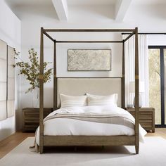 a bedroom with a four poster bed and white walls