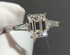 an emerald cut diamond ring with baguettes on the side