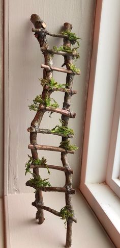 a ladder made out of branches is shown in front of a window with a mirror