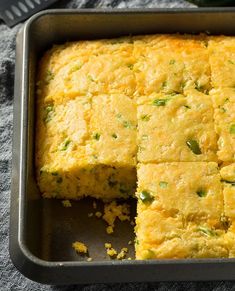 cornbread casserole in a baking pan with slices cut out and ready to be eaten