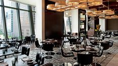 an empty restaurant with tables and chairs in front of large windows, overlooking the city