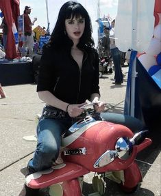 a woman riding on the back of a red motorcycle