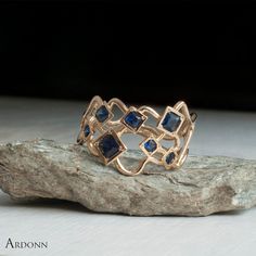 An exquisite Blue Sapphire Ring that has been sitting in my mind for a long time. This unique rings is made out of twisting pipes and squares from Solid Gold.  A unique asymmetrical design, with shifting patterns of curves and squares. Featuring 7 Squares is total in set with Blue Sapphires of various sizes between 2-4mm. All the Sapphires are natural with a deep medium Blue, With Excellent clarity.  Here is a True to scale PDF File you can download and print on your home printer then cut out... Blue Sapphire Engagement Ring, Engagement Ring Prices, Blue Sapphire Ring, Blue Stone Ring, Sapphire Engagement Ring Blue, Etsy Gold Ring, Sapphire Engagement Ring, Half Eternity Ring, Blue Sapphire Rings