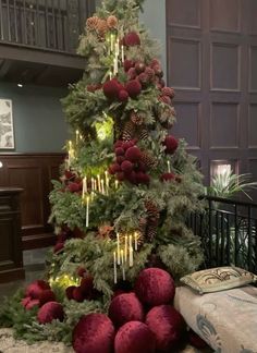 a christmas tree decorated with red balls and pine cones