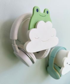 there are two headphones attached to the wall with a frog on one side and a cloud on the other