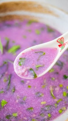 a spoon full of purple and green soup