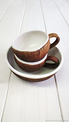 two bowls with wooden handles are sitting on a plate