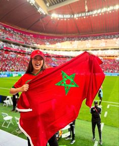 a woman holding up a red flag at a soccer game