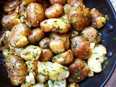 a pan filled with potatoes and herbs on top of a table