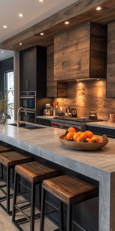 a bowl of oranges sitting on top of a kitchen counter next to stools