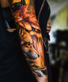 a man's arm with a fox and leaves on it