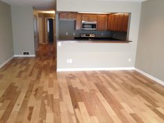 an empty living room with hard wood flooring