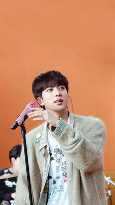 a young man standing in front of a microphone