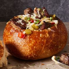 a bread bowl filled with meat and vegetables