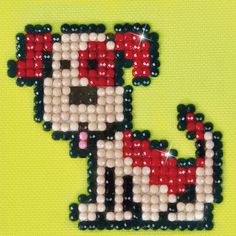 a cross stitch bead pattern of a dog wearing a santa hat on a green background