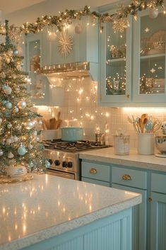 a kitchen decorated for christmas with lights on the cabinets and a tree in the corner